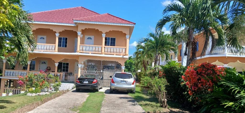 a house with cars parked in front of it at Cindy's Garden Stay in Ocho Rios