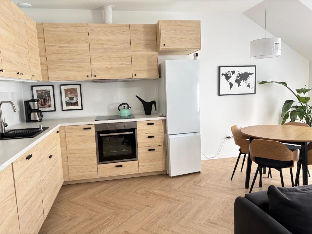 a kitchen with a white refrigerator and a table at Dobre Miejsce in Skoczów