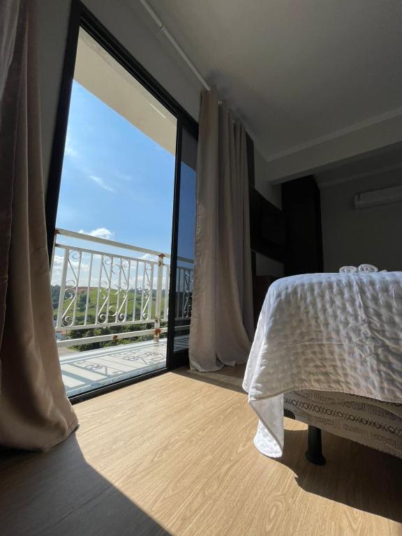 a bedroom with a bed and a large sliding glass door at Hotel Bela Vista Palace in Araçariguama