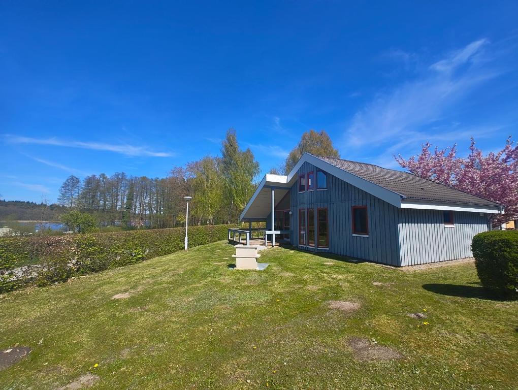a blue house on a hill with a yard at Wildgans 5A in Mirow
