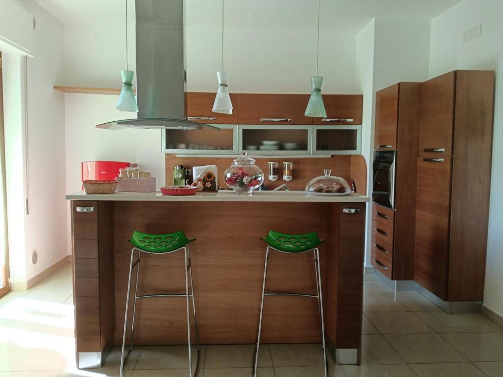 a kitchen with a island with two bar stools at Sweet holidays in Matera