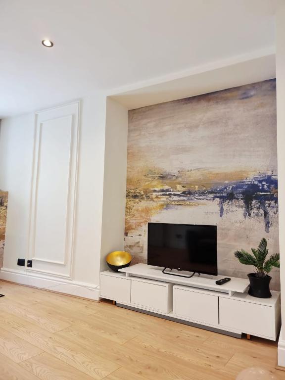a living room with a flat screen tv on a white cabinet at Luxury Holiday Apartments in Torquay