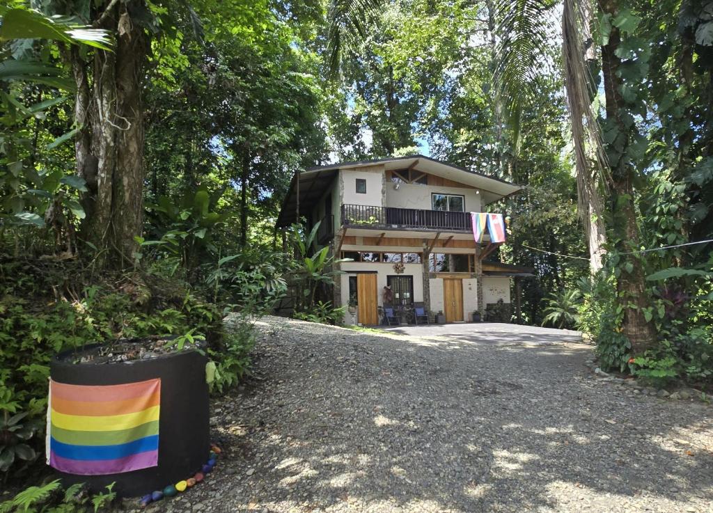 a house with a rainbow sign in front of it at Nature Lovers Quepos in Quepos