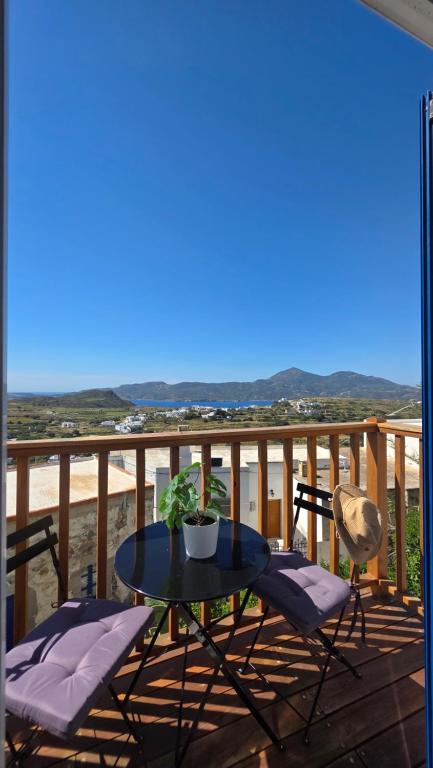 a table and chairs on a balcony with a view at Spitaki Milos in Tripiti