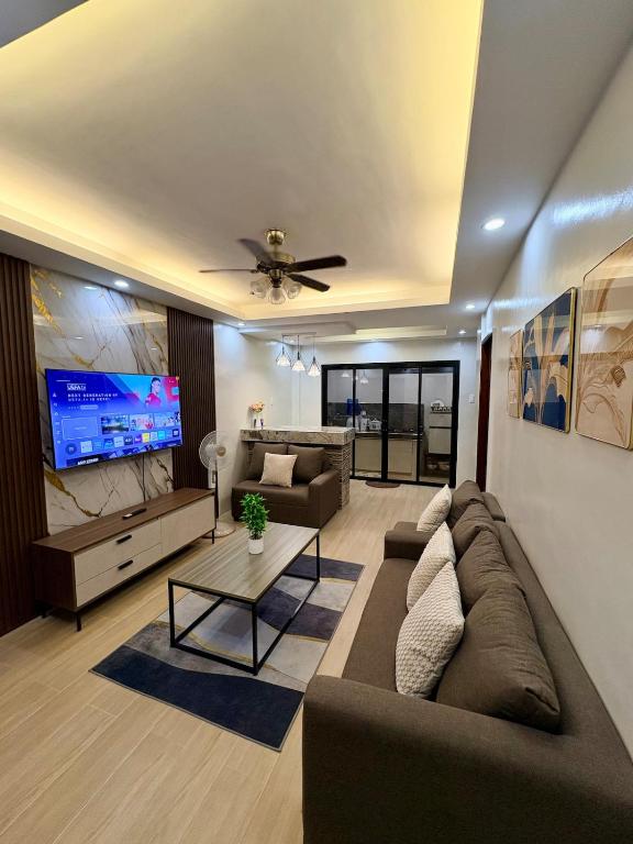 a living room with a couch and a flat screen tv at Arceo Homestay 2 Bedroom unit in Puerto Princesa City