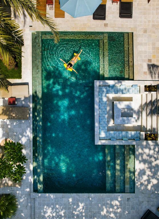 a swimming pool with a man in the water at Gila House - Adults only in Gili Islands