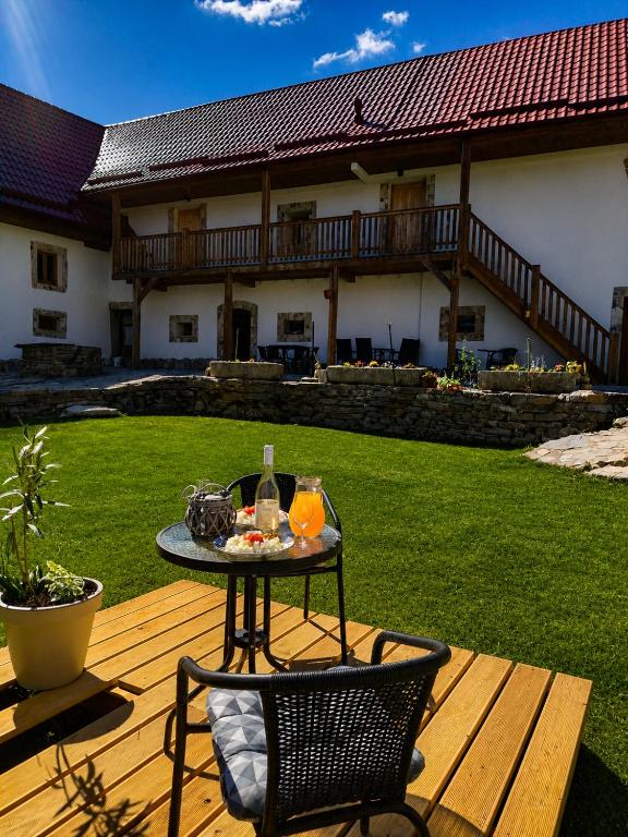 a table with a bottle of wine and two chairs on a deck at Jílová tvrz in Rožmberk nad Vltavou