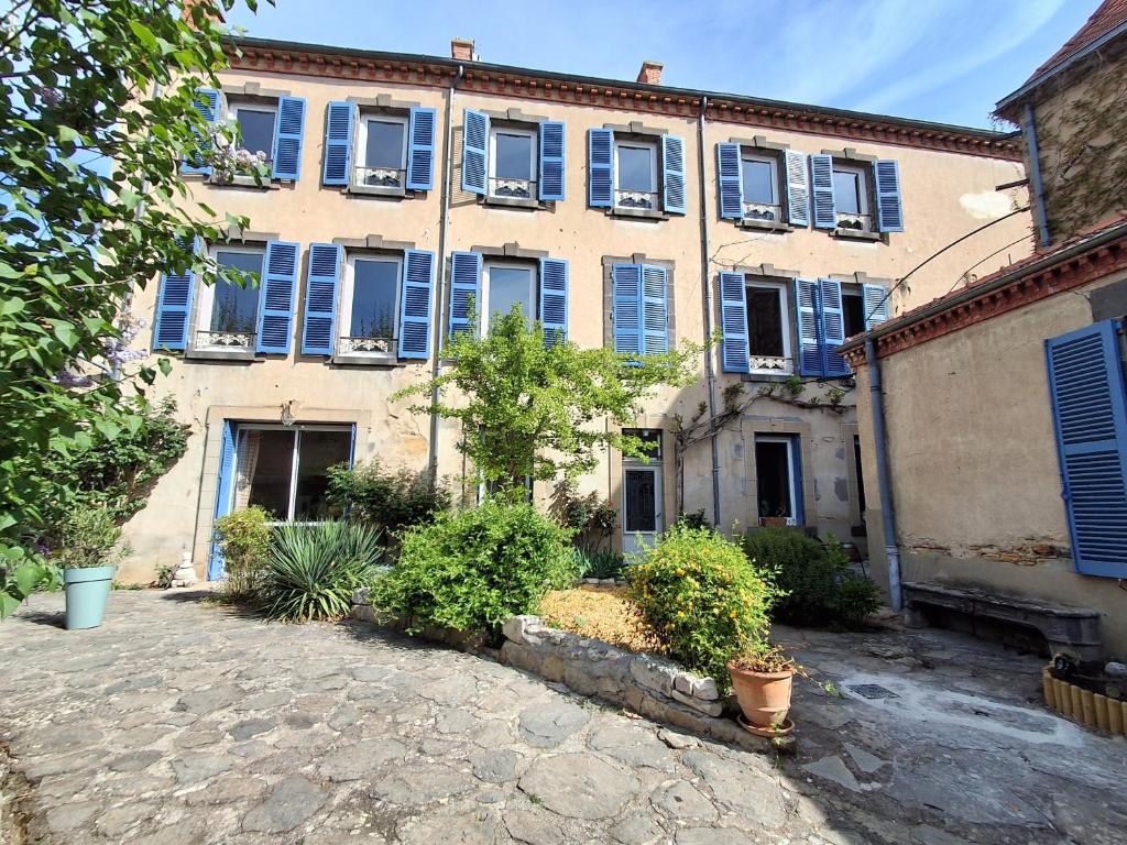 an old building with blue windows and plants at Villa Toscane in Saint-Germain-Lembron