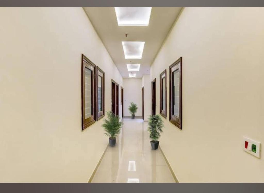 ein leerer Flur mit zwei Topfpflanzen in einem Gebäude in der Unterkunft Hotel Moontrip in Mohali