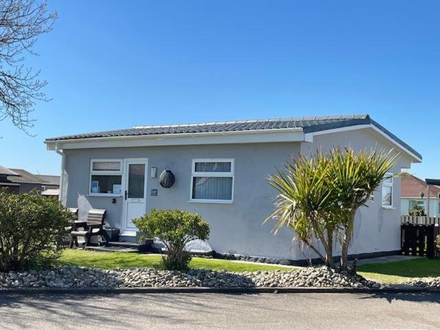 a white house with a bench in front of it at Chalet 147 South Shore Bridlington in Bessingby