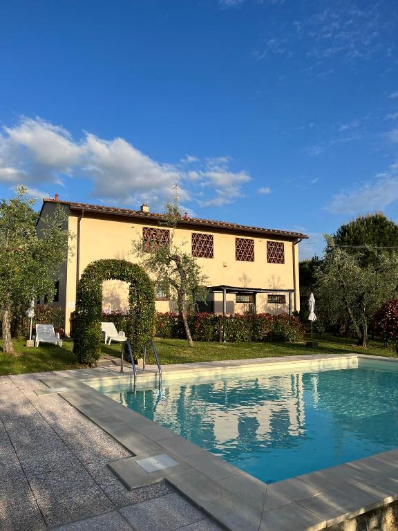 a swimming pool in front of a house at Agriturismo IL VIAIO in Fiesole