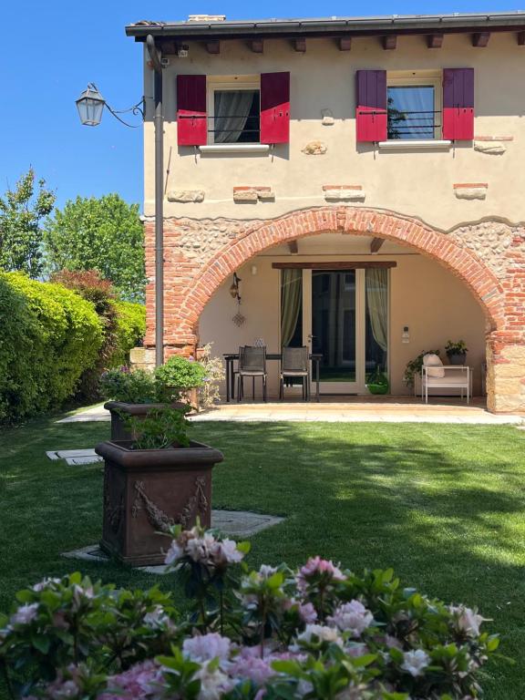 a house with an archway in a yard with flowers at Dolce Vita in Altivole