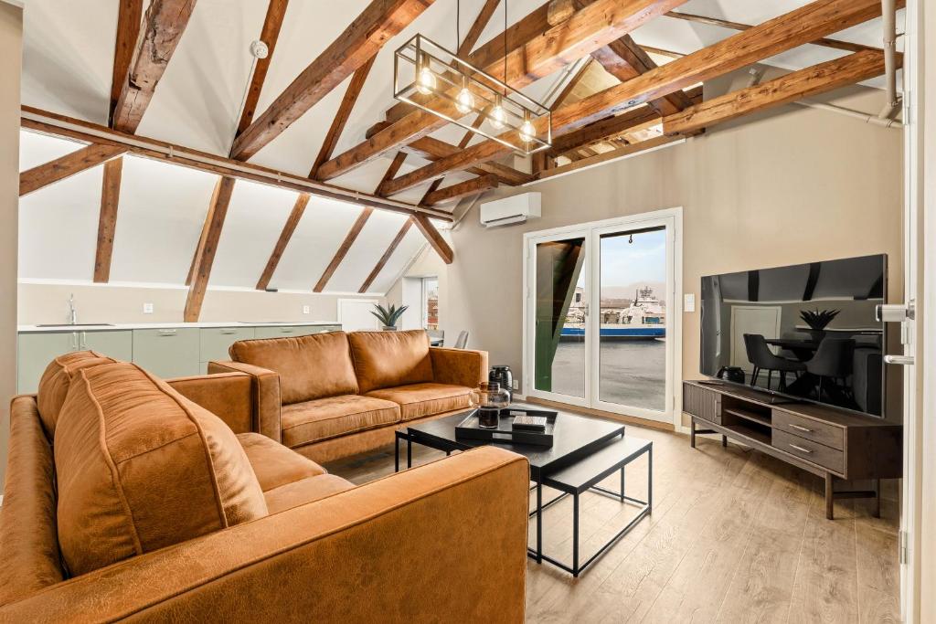 a living room with a couch and a tv at 2026 New built Aparthotel - 5 units - 4BR - 2BR - SKB17 in Bergen