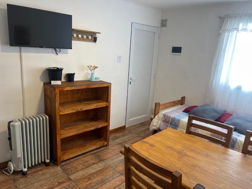 a living room with a television and a table and a bed at Mageeva Miramar Bs As Argentina Departamentos in Miramar