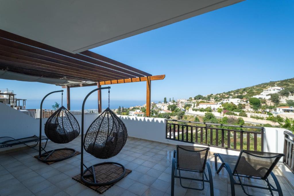a balcony with chairs and a view of the ocean at Peyia Hilltop Retreat - Village Views & Sunsets in Peyia