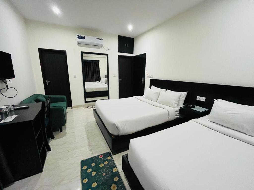 a hotel room with two beds and a desk at Marineview Hotel Kuakata in Kuākāta
