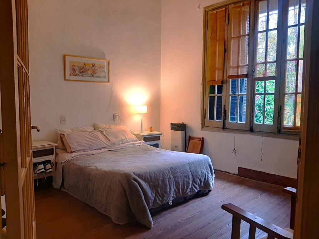 a bedroom with a bed and two windows at Vecchia Casa en el centro in General Villegas