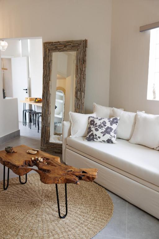 a living room with a white couch and a wooden coffee table at EOS Small House in Pollonia