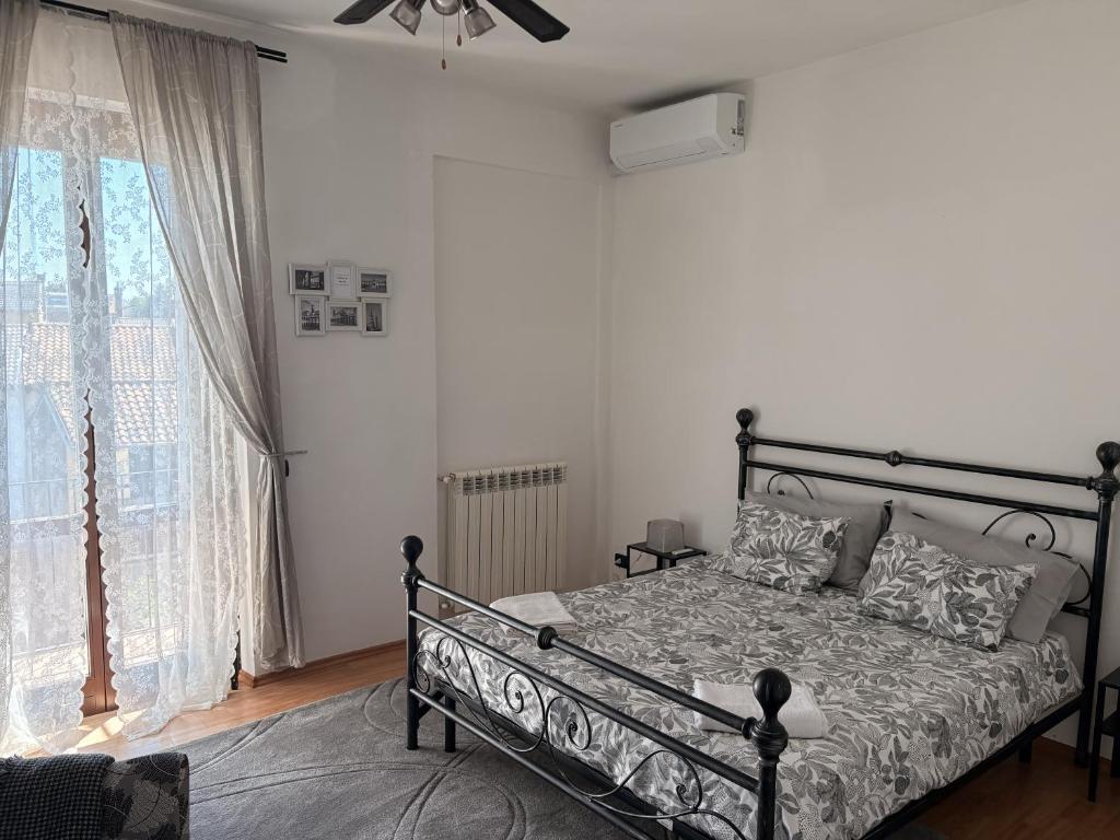 a bedroom with a bed and a large window at Novara Il Gallo in Lumellogno