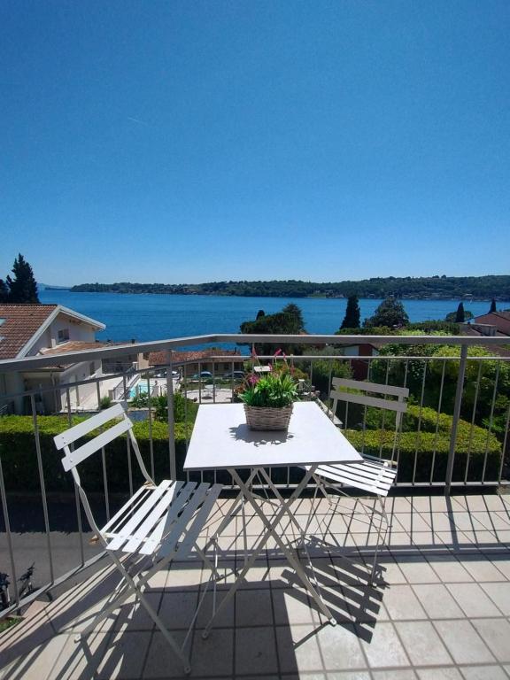 a table and chairs on a balcony with a view of the water at Openspace Sunrise lake view in Salò