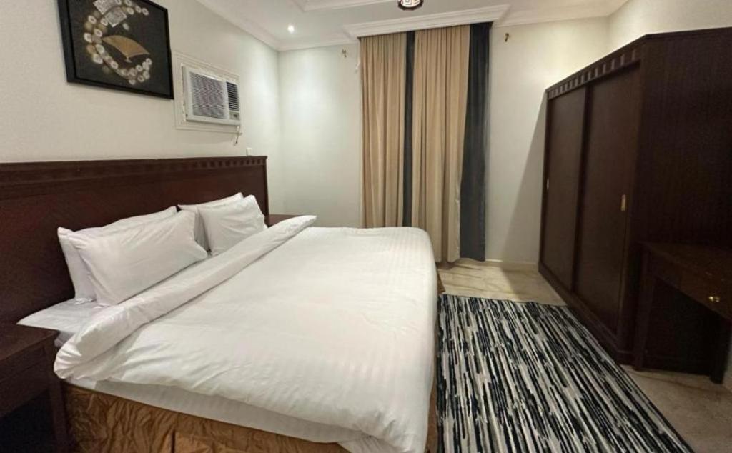 a bedroom with a large bed with white sheets and pillows at مساكن جدة in Jeddah