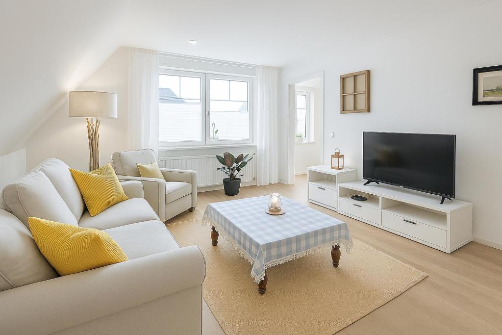 a white living room with a couch and a tv at Kleine Auszeit Pellworm in Pellworm