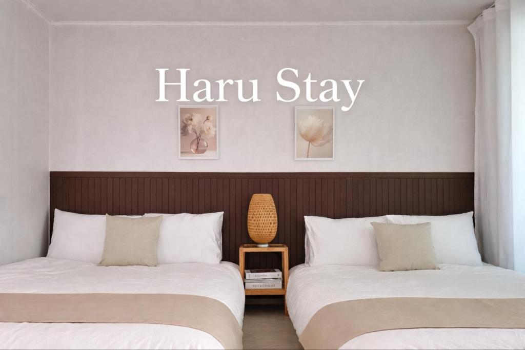 two beds in a room with a harristay sign above them at 수원 행궁 Haru Stay in Suwon