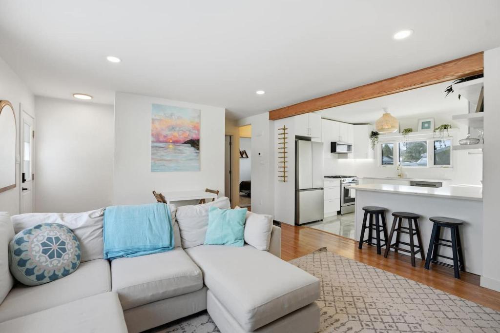 a living room with a white couch and a kitchen at Bright & Fully Renovated Retreat - Holiday Home in Saskatoon