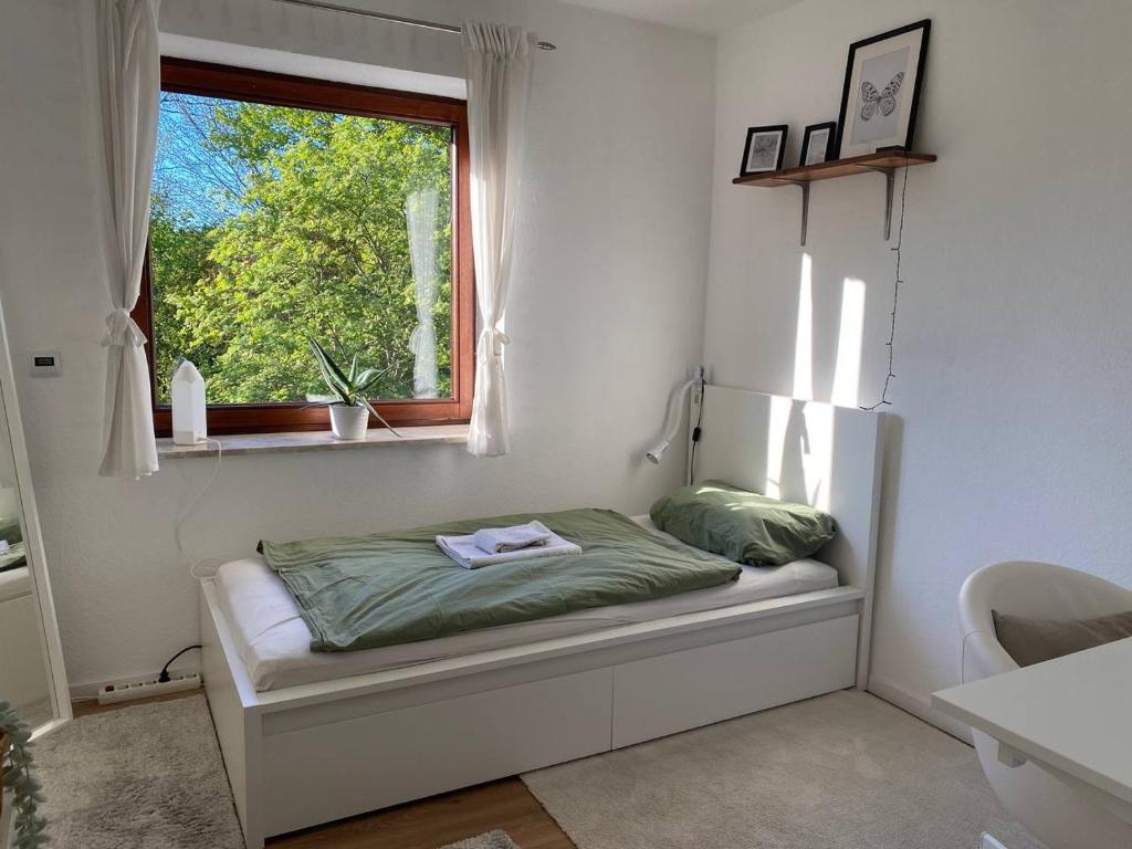 a small bed in a room with a window at Ruhige Ortsrandlage 2 in Kiel