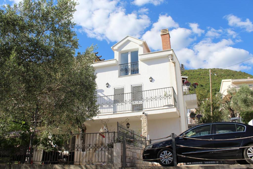 a black car parked in front of a white house at Villa Lime in Petrovac na Moru