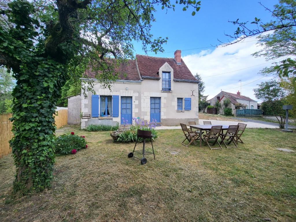 a house with a table and chairs in the yard at La Petite Rochette in Chédigny