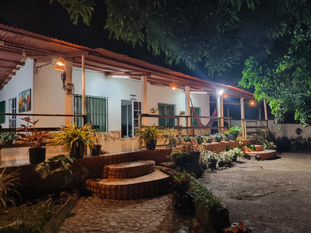 a building with a bunch of potted plants in a courtyard at Casa Finca la Casona con Piscina Privada - Cerca al Parque Tayrona in Santa Marta