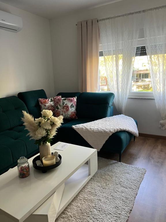 a living room with a green couch and a table at Stan na dan Ana in Prozor