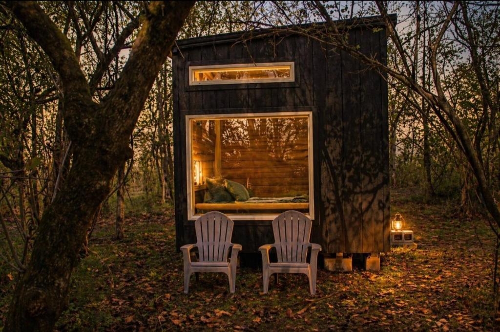 two chairs sitting in front of a tiny house at Meadowview Springs in Louisville