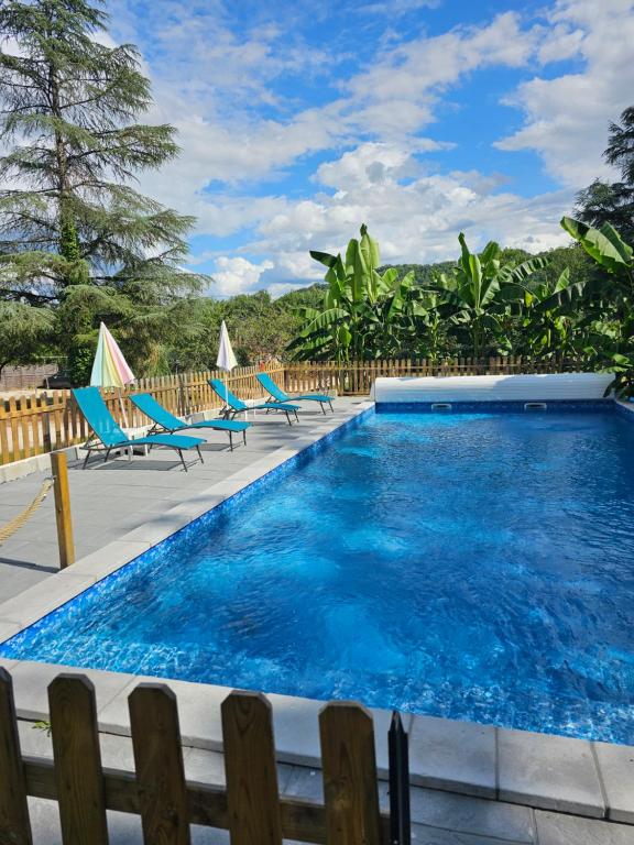 a swimming pool with blue chairs at Domaine mon doux rêve in Terrasson-Lavilledieu
