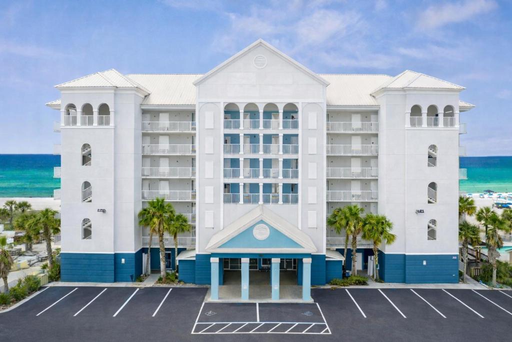 a hotel with the ocean in the background at Palm & Tide Beachfront Hotel in Panama City Beach
