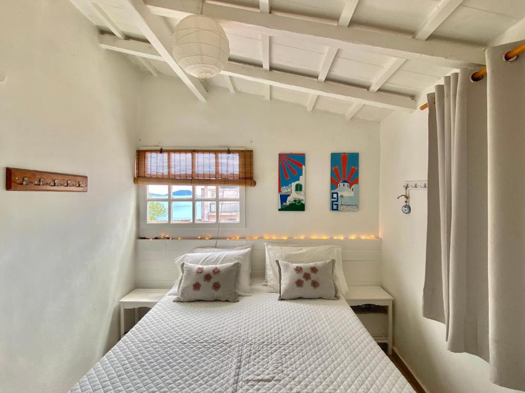 a bedroom with a white bed with two pillows at Boat House in Loutraki