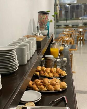 a counter in a kitchen with plates of food at Hotel Royal in Neuquén