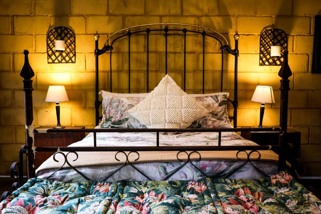 a bedroom with a large bed with two lamps at Mercy Tree Manor in eMalahleni