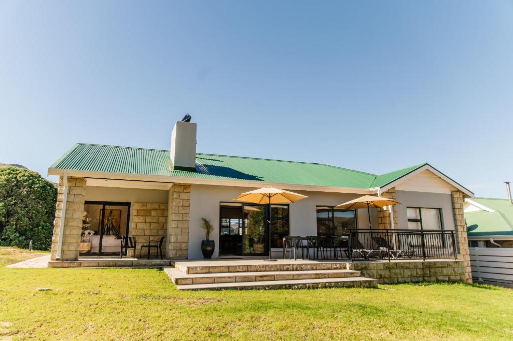 a house with two umbrellas in front of it at Pause Guesthouse in Clarens
