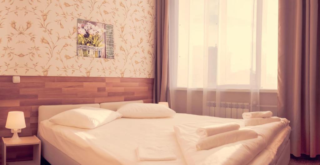 a white bed in a room with a window at Ahouse Hotel on Nakhimovsky Prospekt in Moscow