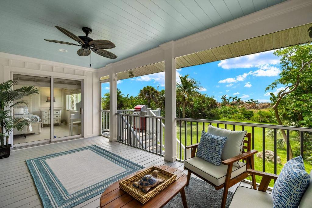 a screened porch with a chair and a ceiling fan at Turtle Caye in Sanibel