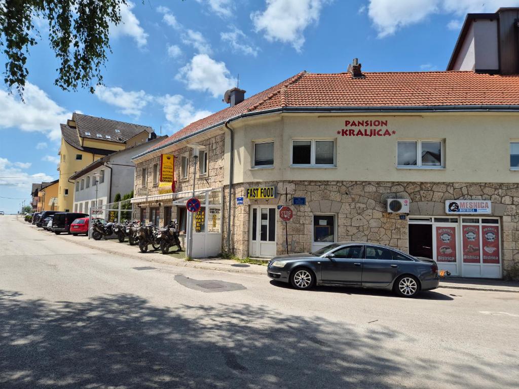 a car parked in front of a building on a street at Soba za goste Kraljica 4 in Kupres
