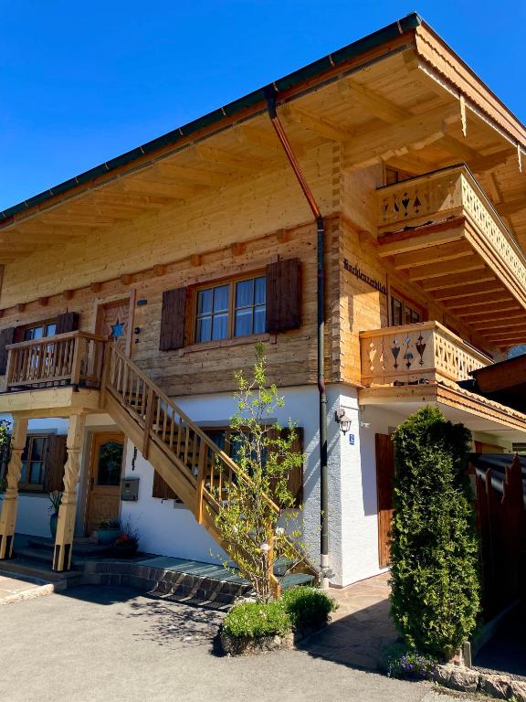 a large wooden house with a staircase on it at Haus Hochlenzerblick in Schönau am Königssee