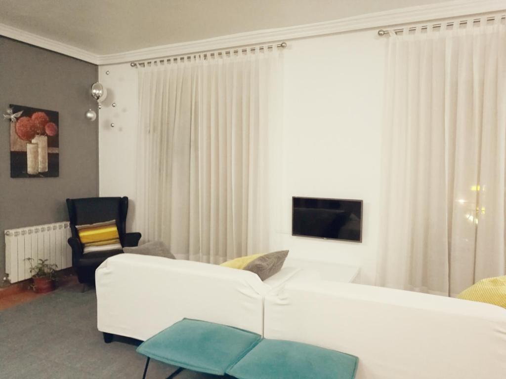 sala de estar con sofá blanco y silla en Hostal Terán en Madrid