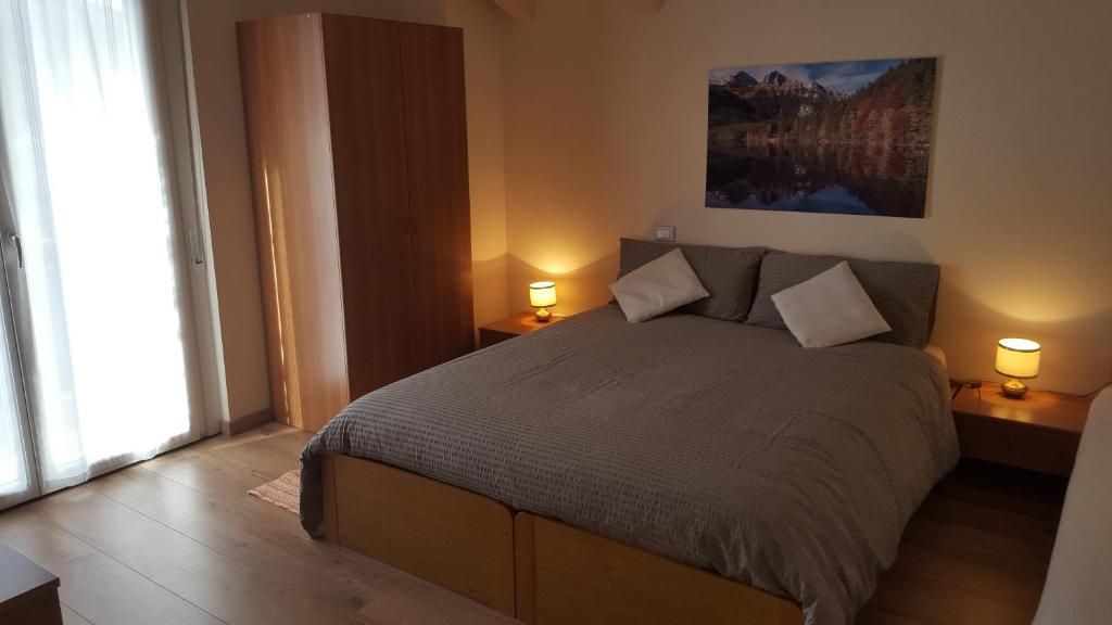 a bedroom with a large bed with two lamps at Villa Ducati in Vattaro