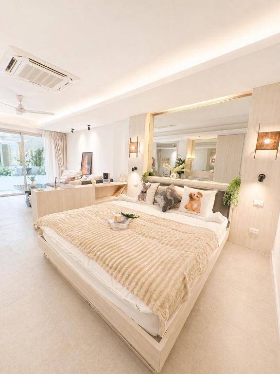 a large bedroom with a large bed and a living room at Green View Condo in Kathu