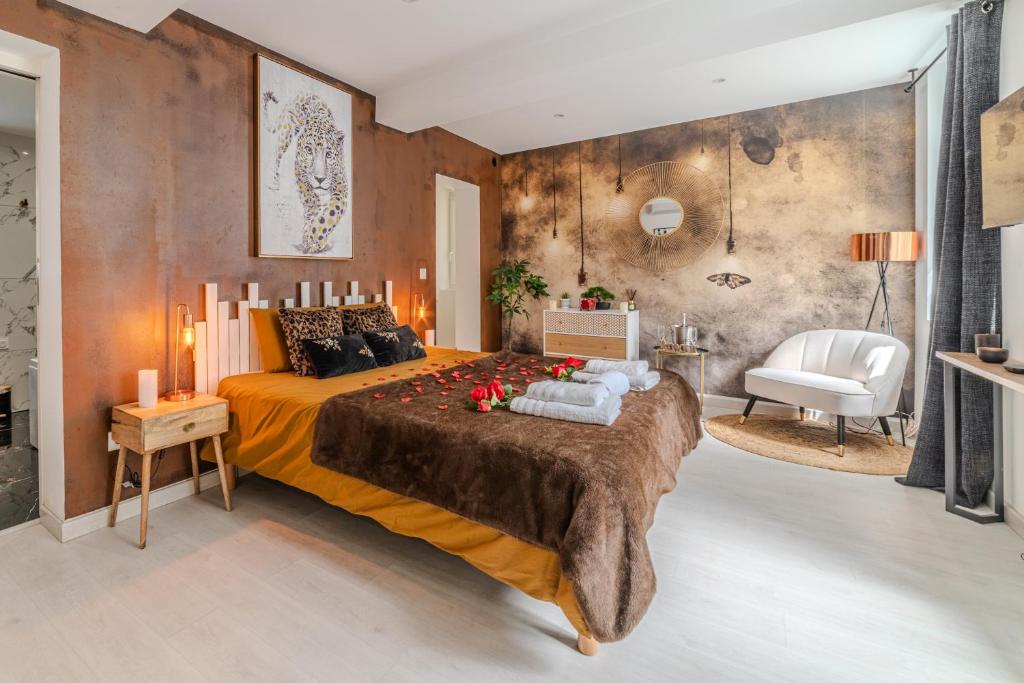 a bedroom with a large bed and a chair at LOVE ROOM - Amour Chic et Intime in Montbrison