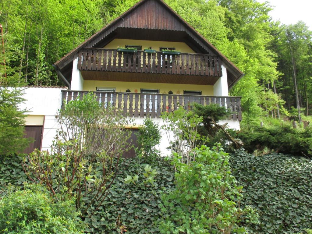a house with a balcony in the woods at Apartment in Behringersmühle in Gößweinstein