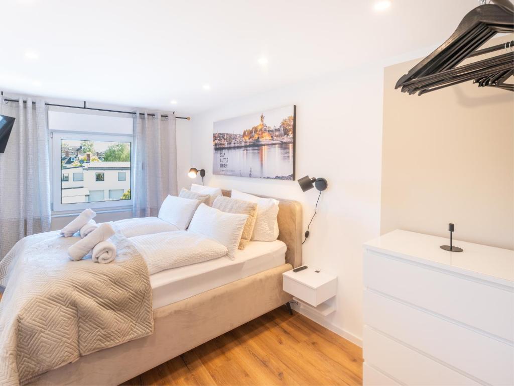 a white bedroom with a bed and a window at Zeitwohnstudios work & stay - modern, vollausgestattet für Selbstversorger in Koblenz